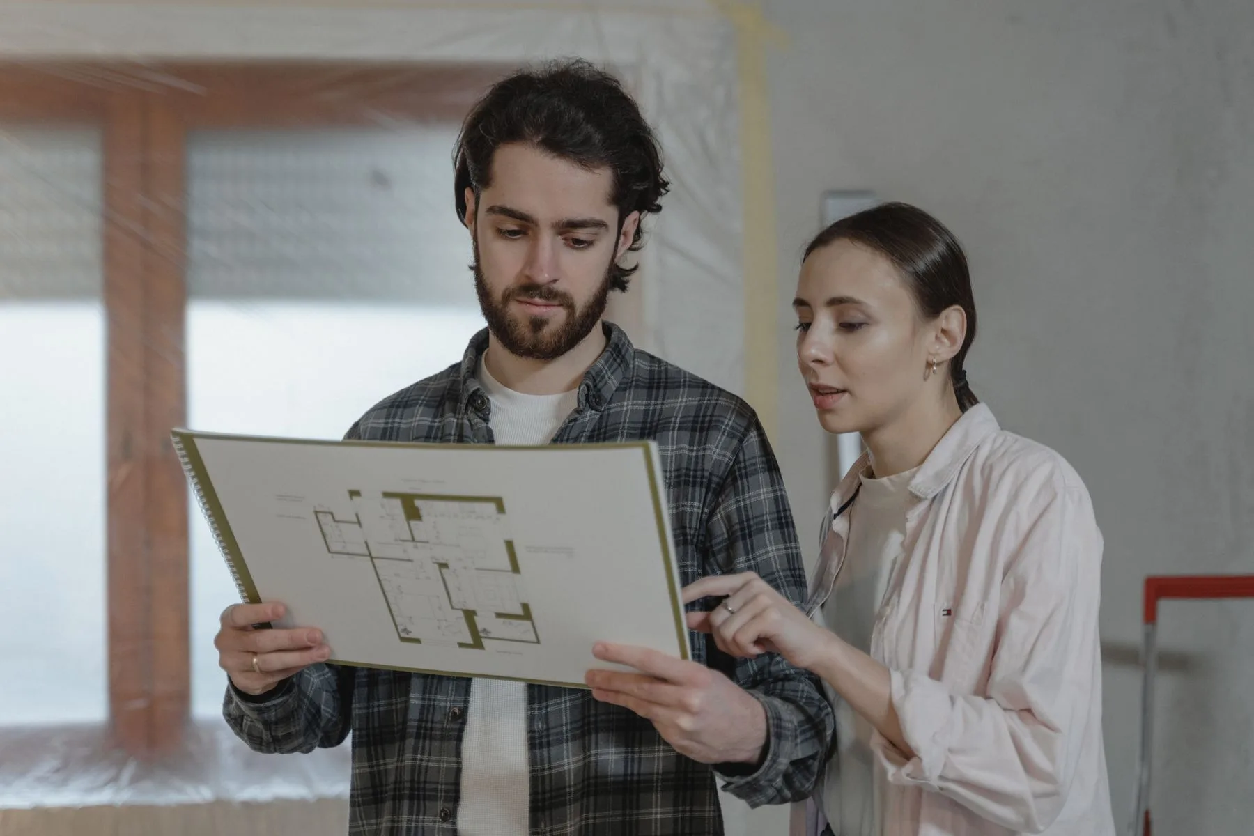 SOMO project lead reviewing a floor plan with a homeowner inside a Bay Area home being renovated
