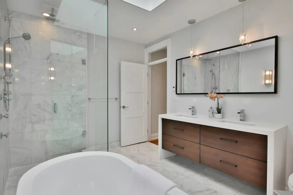 Marble bathroom with floating walnut vanity and glass shower