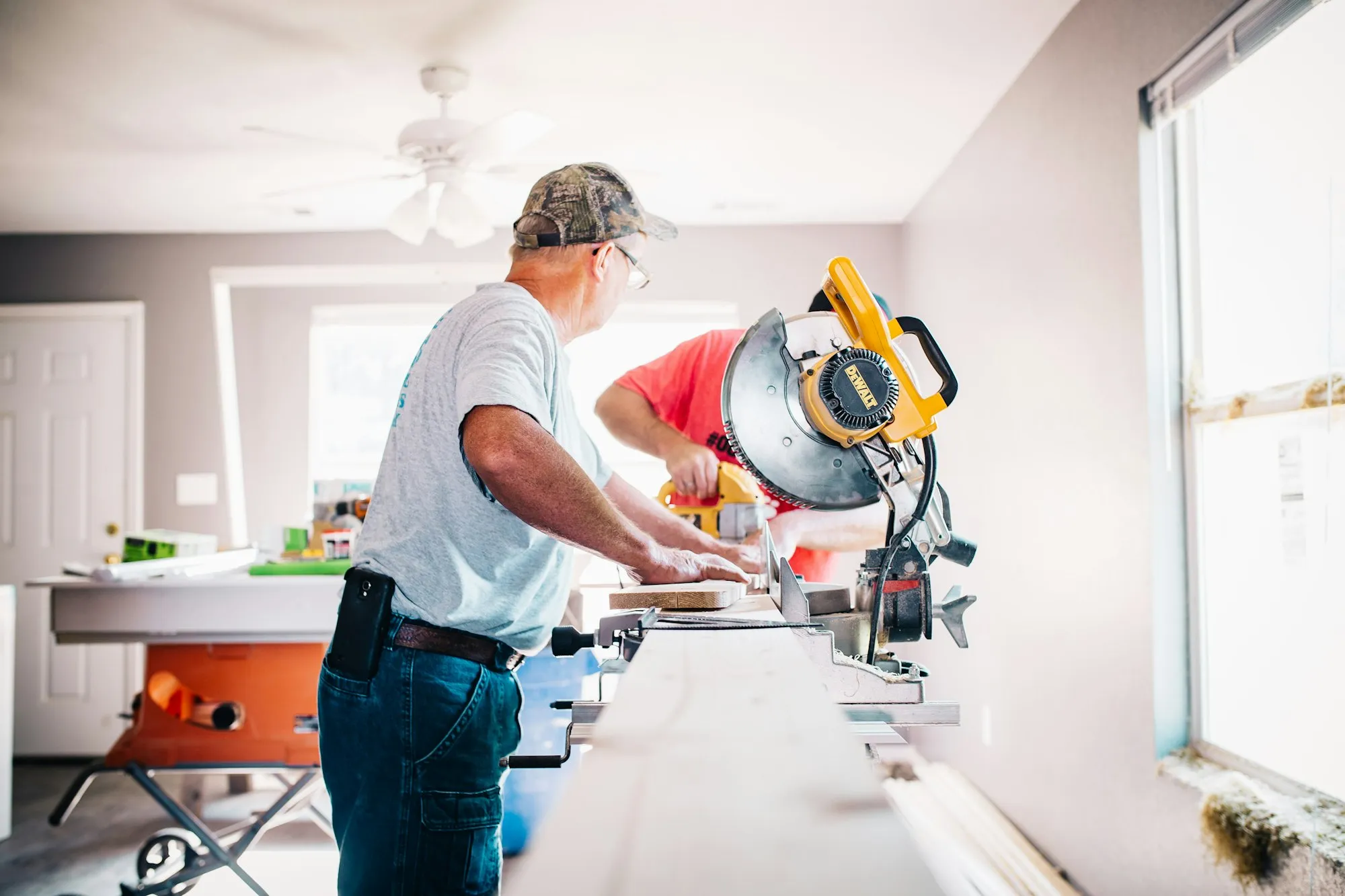 Carpenters measuring and cutting trim with a miter saw