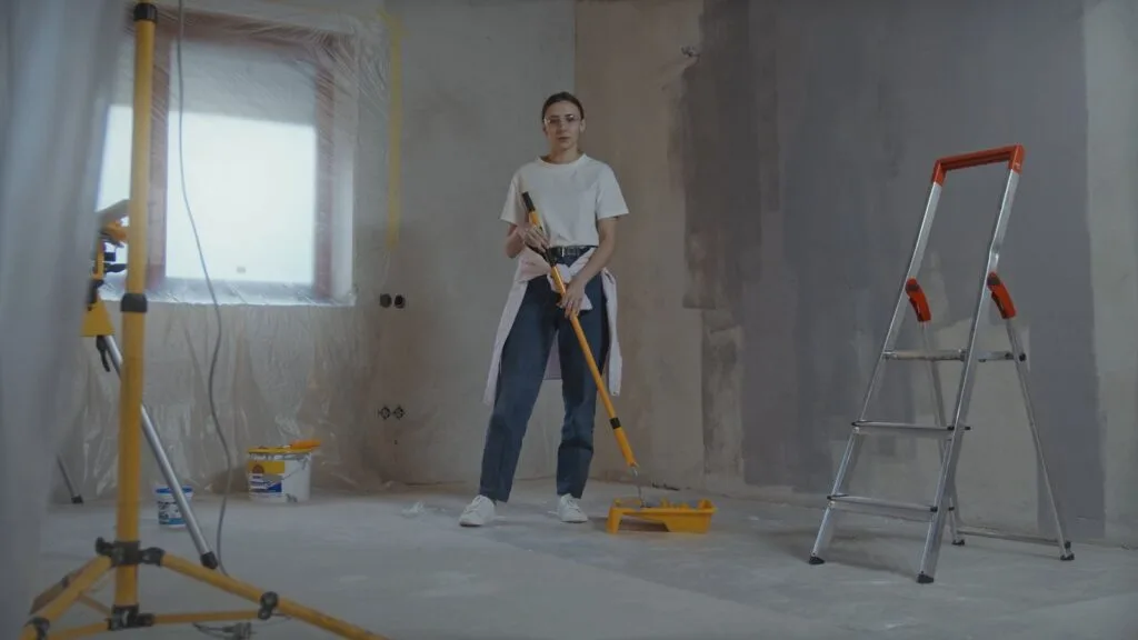 Room mid-renovation with work light, ladder and floor protection