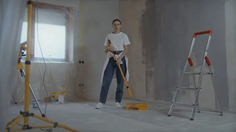 Room mid-renovation with work light, ladder and floor protection
