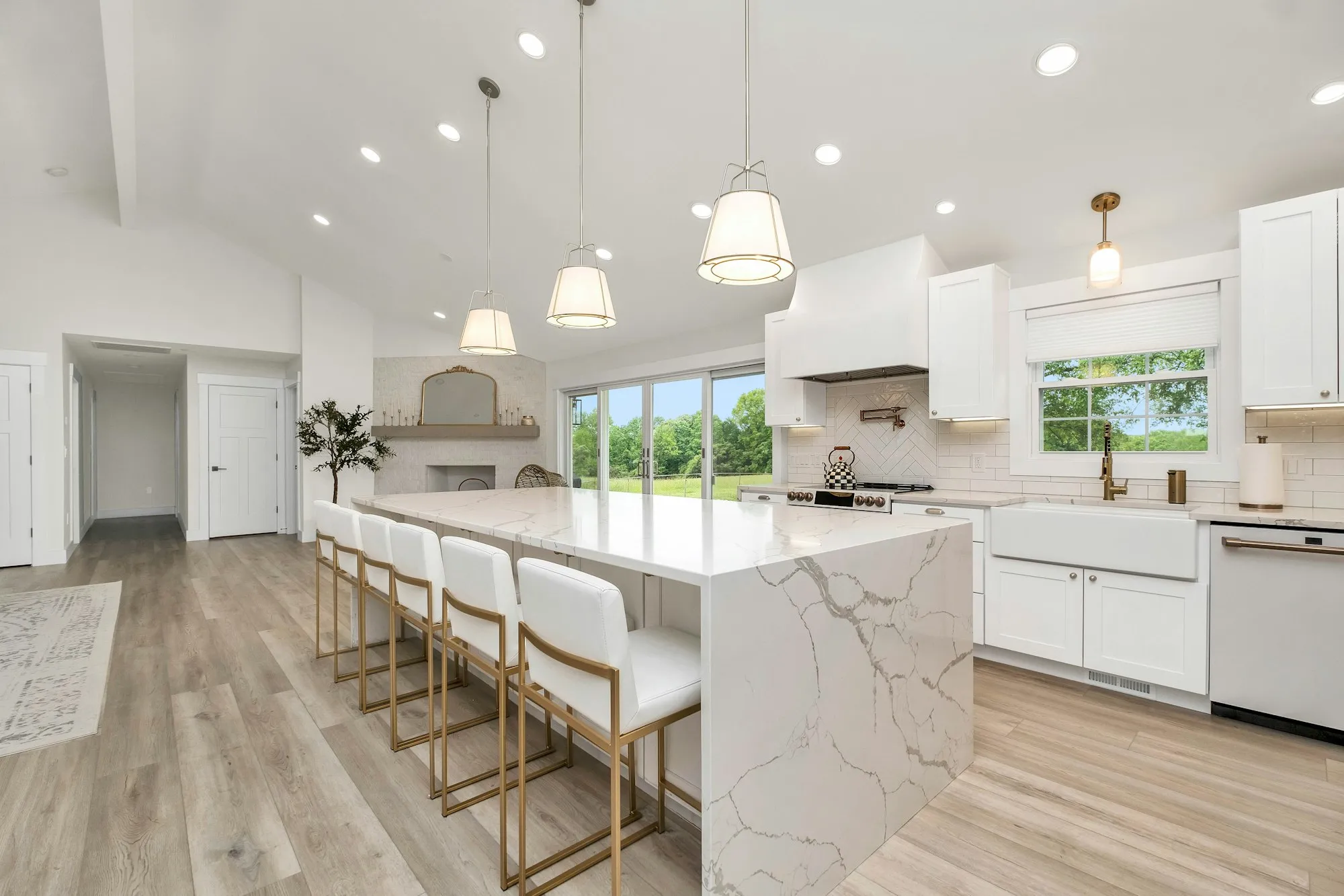 Bright kitchen with marble waterfall island and pendant lights