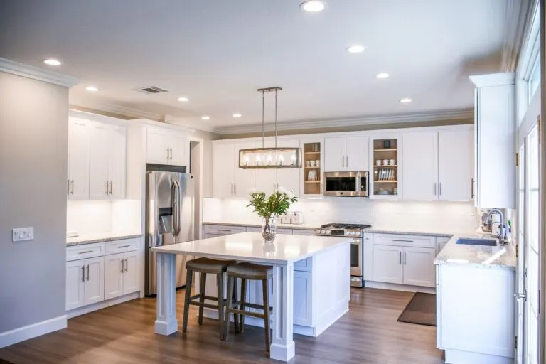 Modern kitchen remodel with white shaker cabinets, quartz island and pendant lighting